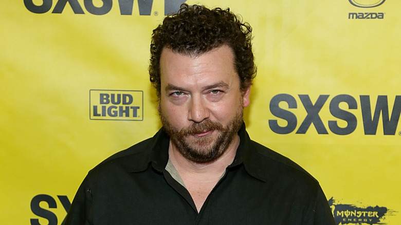 Danny McBride posing in front of a yellow background at SXSW