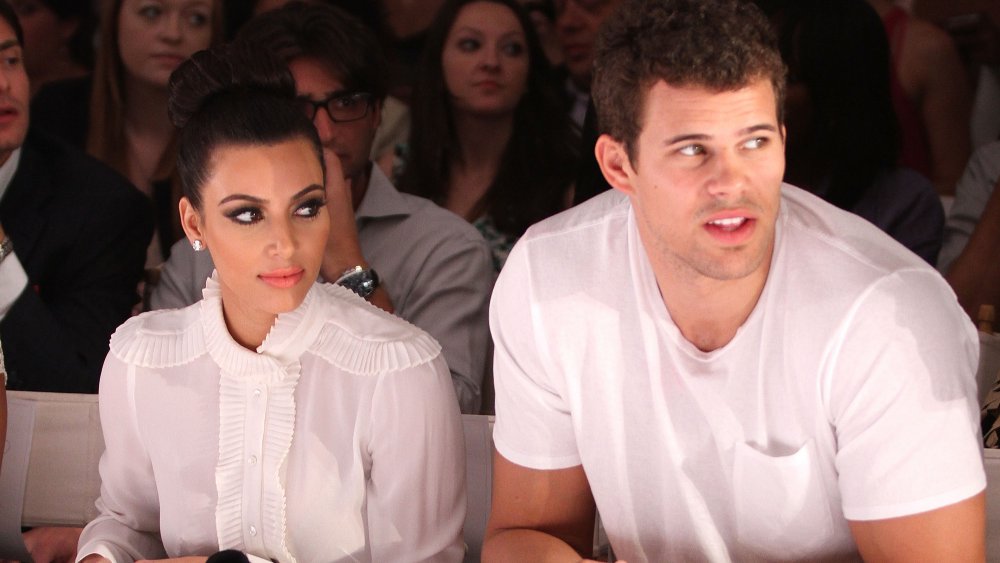 Kim Kardashian and Kris Humphries sitting next to each other