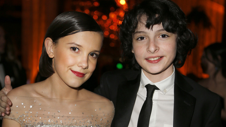 Finn Wolfhard with arm around Millie Bobby Brown