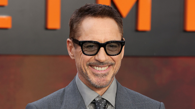 Robert Downey smiling in sunglasses and gray suit