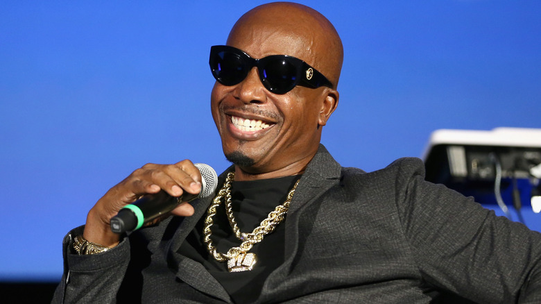 MC Hammer wearing a gray suit and gold chains