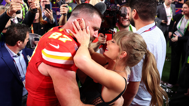 Taylor Swift grabbing Travis Kelce's face