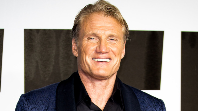 Dolph Lundgren smiling in blue jacket