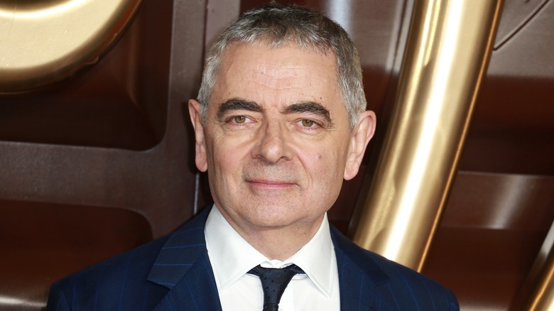 Rowan Atkinson smiling in blue suit