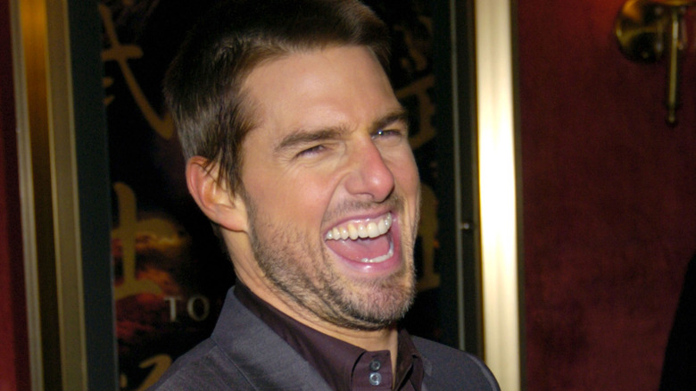 Tom Cruise laughing in grey suit