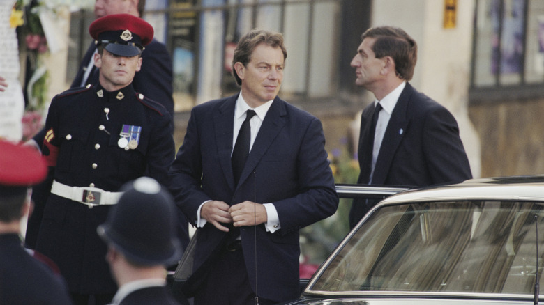 Tony Blair buttoning his suit coat