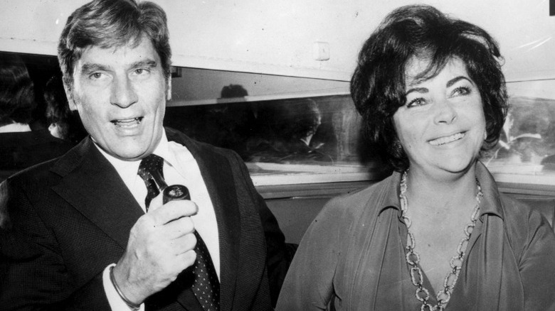 John Warner holding pipe, Elizabeth Taylor smiling