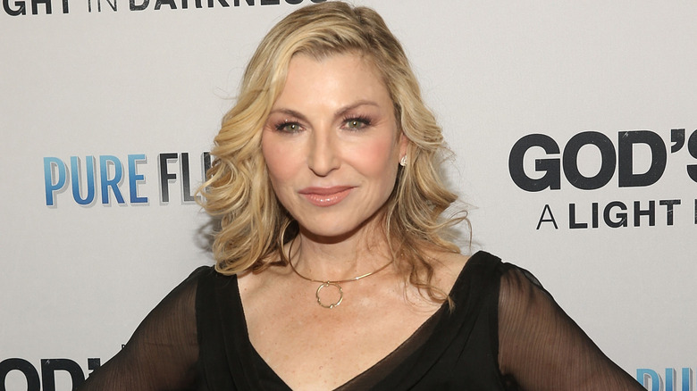 Tatum O'Neil smirking in a black dress on the red carpet