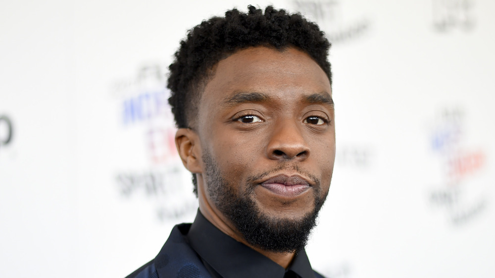 Chadwick Boseman looks off to the side