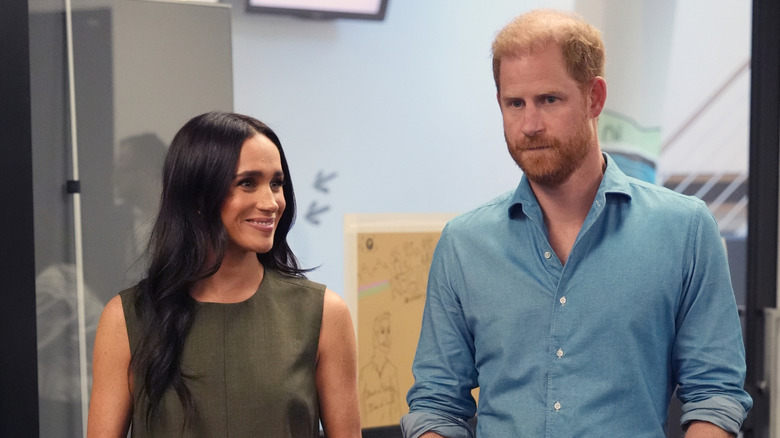Meghan Markle smiling beside Prince Harry.