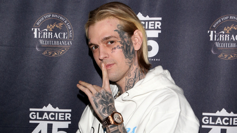Aaron Carter with tattoos and a white hoodie