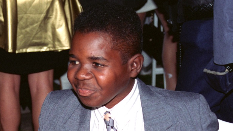 Dressed in a grey suit and white shirt, Gary Coleman sports a cheeky grin
