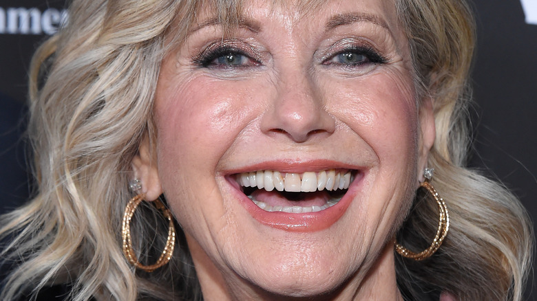 Olivia Newton-John poses in gold hoop earrings