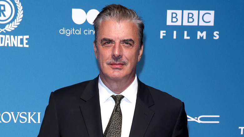 Chris Noth in black suit, posing