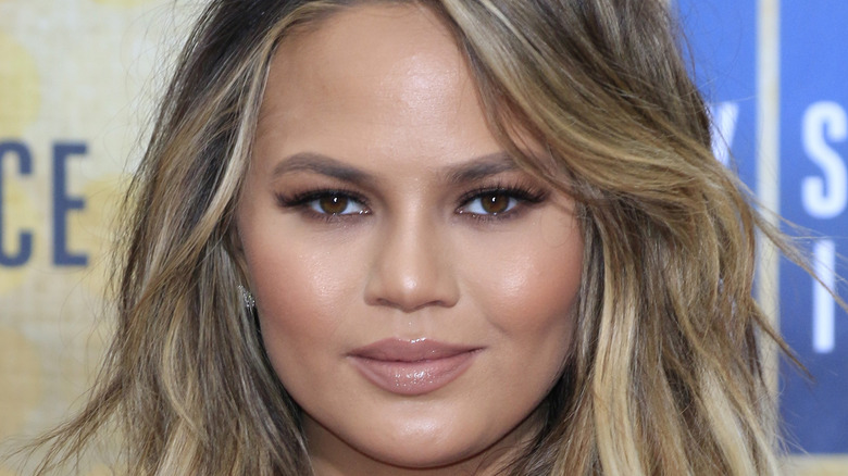 Chrissy Teigen smiling on the red carpet