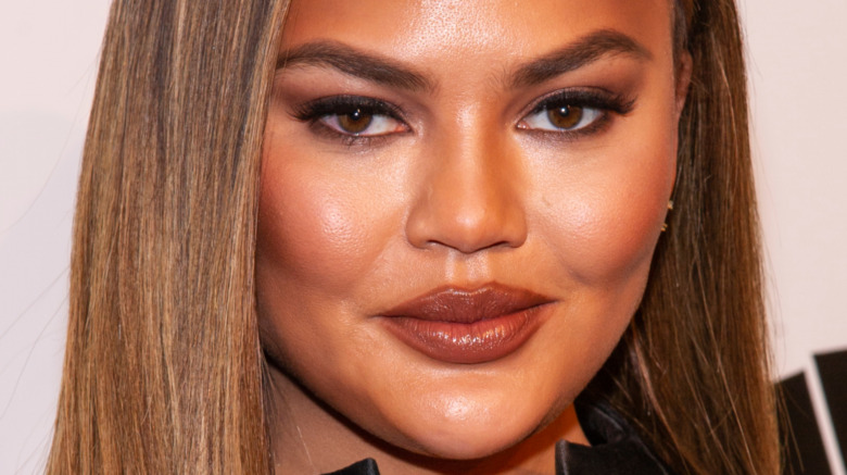 Chrissy Teigen with a neutral expression