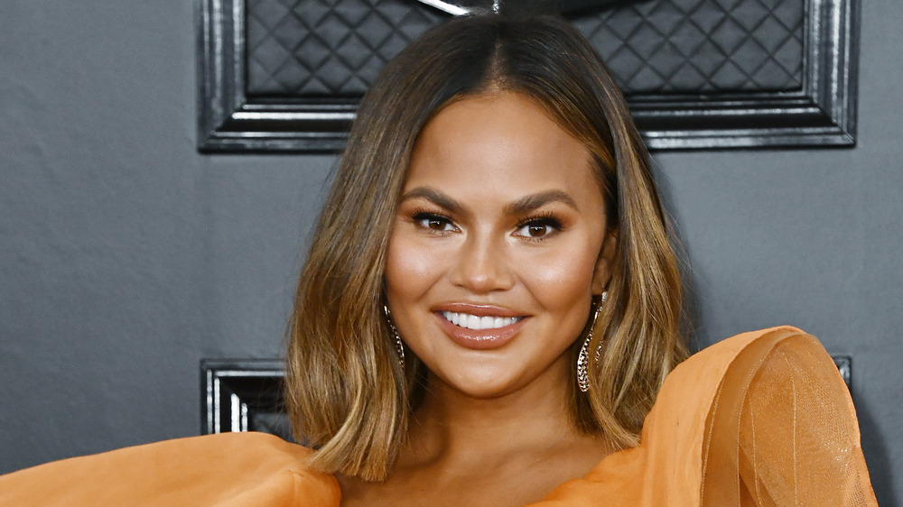 Chrissy Teigen smiling on the red carpet