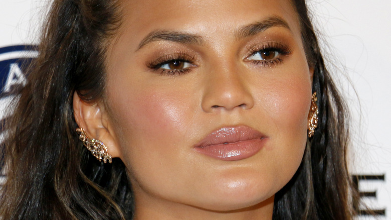 Chrissy Teigen poses in sparkly earrings