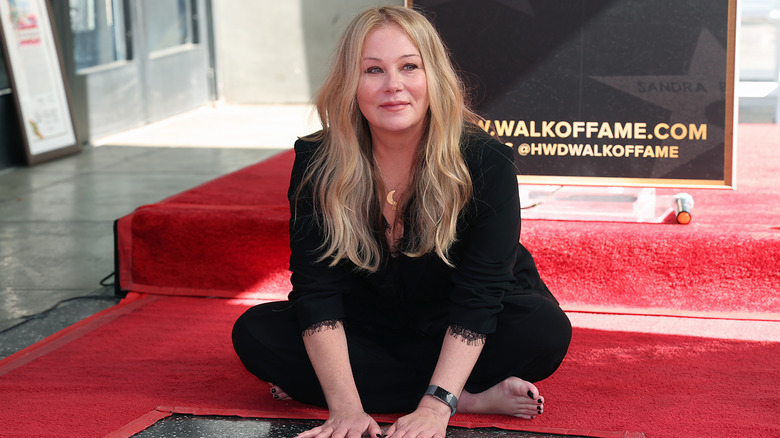 Christina Applegate touching her star on the Hollywood Walk of Fame