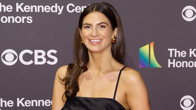 Kaitlan Collins with wavy hair and gold earrings