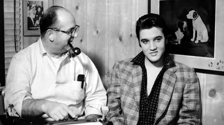 Elvis Presley sits with Colonel Tom Parker