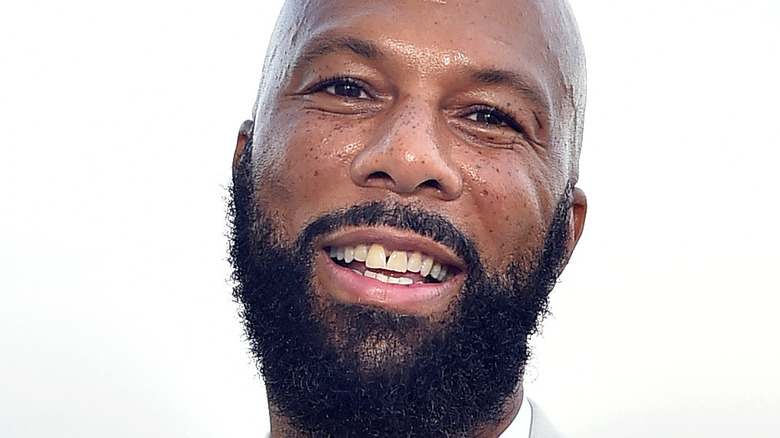 Common flashes a smile at an event