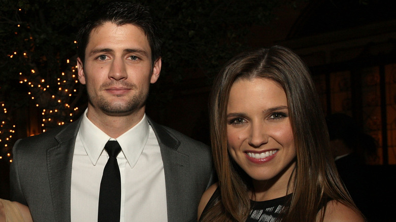 James Lafferty and Sophia Bush posing and smiling together