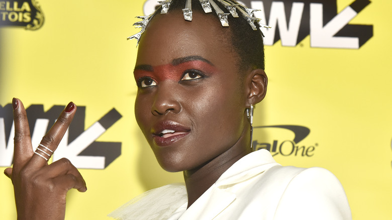 Lupita Nyong'o shows the peace sign