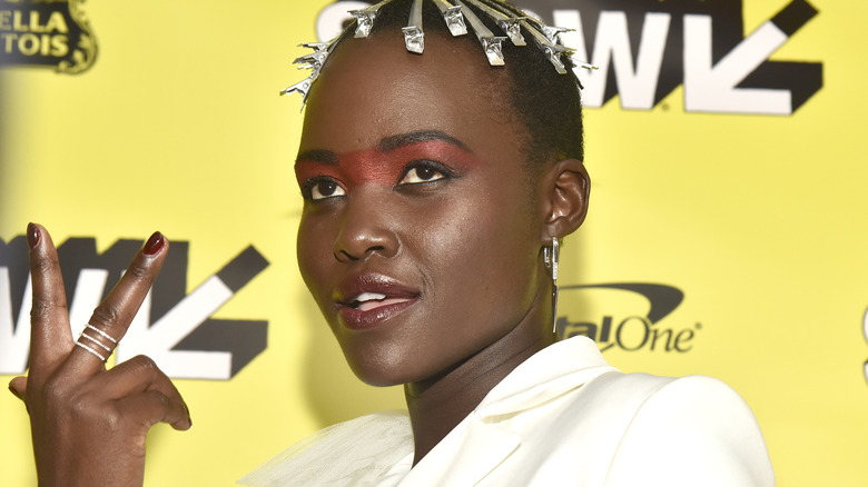 Lupita Nyong'o shows the peace sign