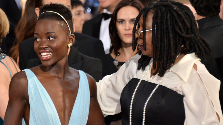 Lupita Nyong'o and Whoopi Goldberg with their arms around each other