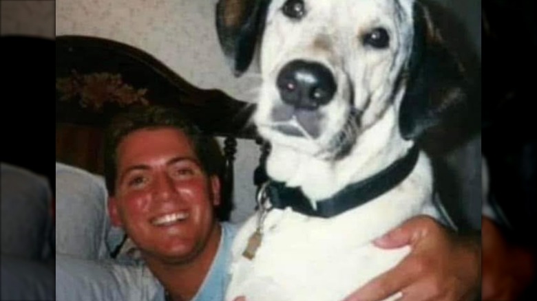 Brian Kinney posing with his dog.