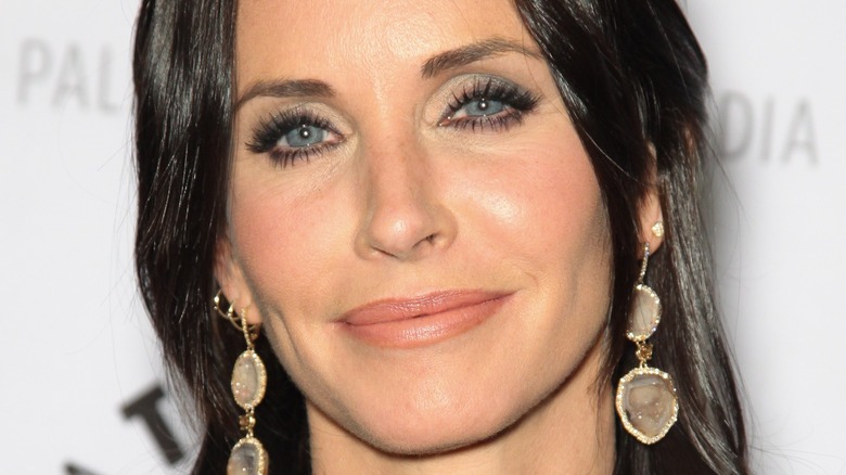 Courteney Cox poses in drop earrings