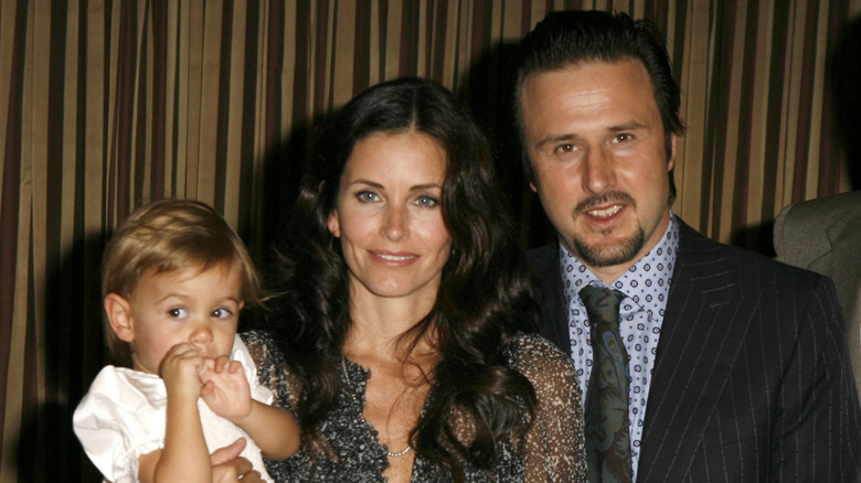 Courteney Cox holding Coco and smiling with David Arquette