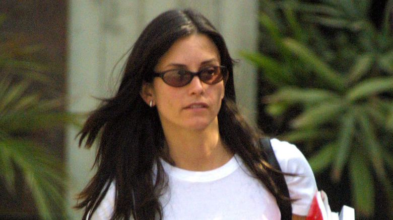 Courteney Cox walking with sunglasses on in 2001