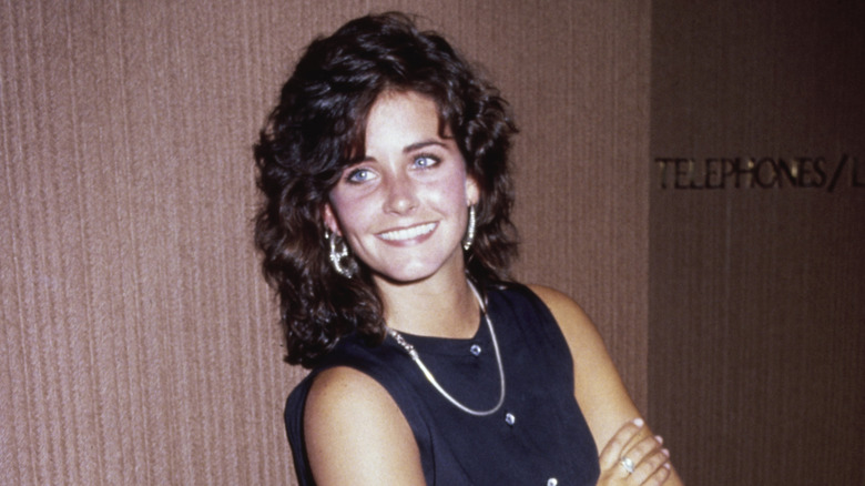 Courteney Cox smiling and posing in 1987