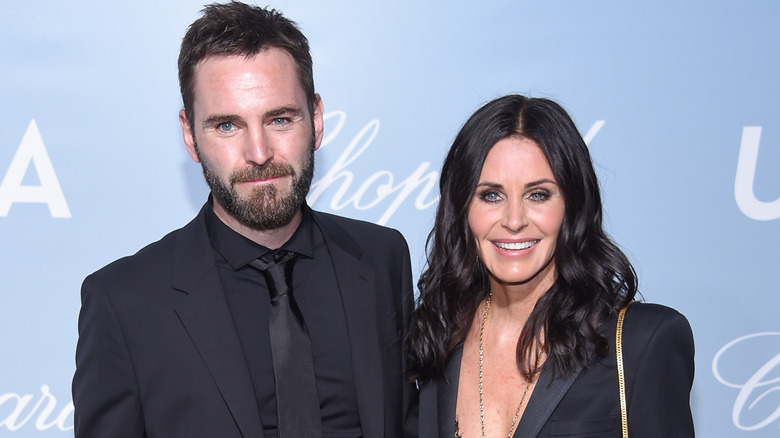 Johnny McDaid and Courteney Cox posing and smiling