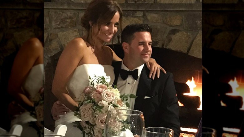 Dianna Russini sitting in Kevin Goldschmidt's lap with her arm around his shoulders on their wedding day.