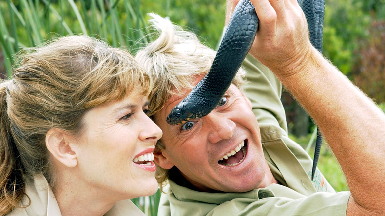 Terri Irwin and Steve Irwin hold a snake.