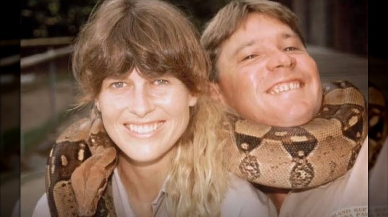 Terri Irwin and Steve Irwin with a snake wrapped around them.