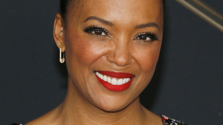 Aisha Tyler smiling in red lipstick at Captain Marvel premiere