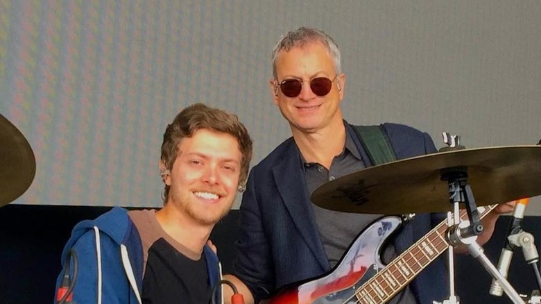 Gary Sinise holding guitar with his son McCanna on drums