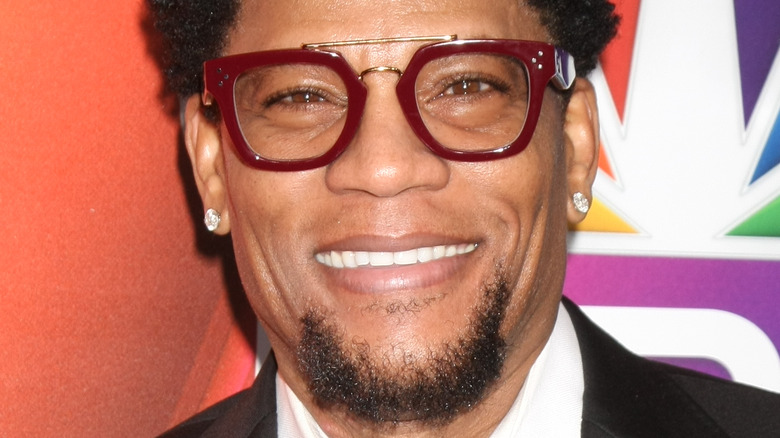 D.L. Hughley wears maroon rimmed glasses