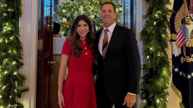 Kristi and Bryon Noem posing together at the White House Christmas party in 2025