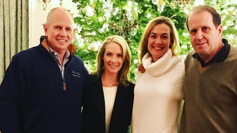 Dana Perino and Peter McMahon posing with Jeff and Tracy Schyberg in front of a  Christmas tree.