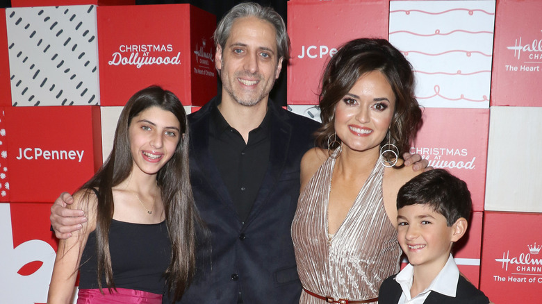 Josh Saviano and Danica McKellar pose with their kids on the red carpet.