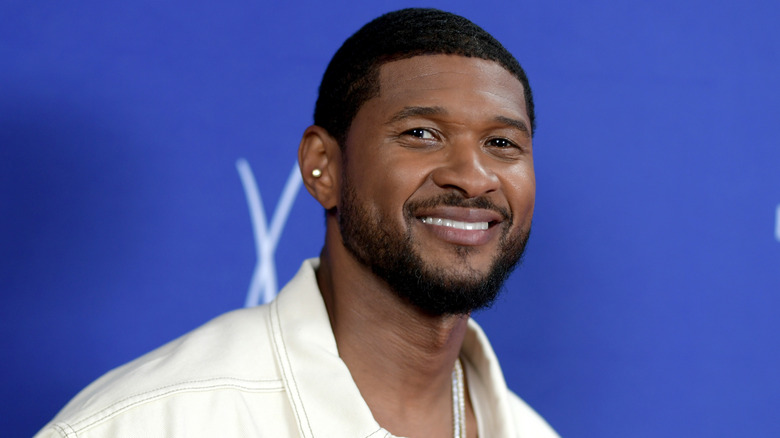 Usher smiling and looking at camera
