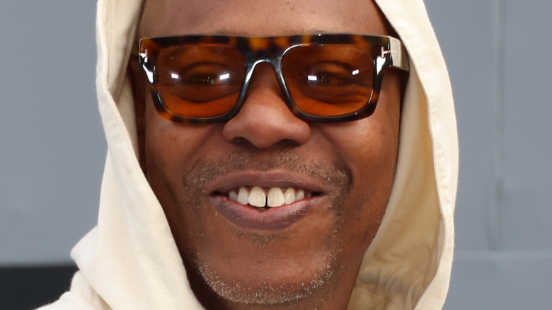 Dave Chappelle in hoodie and glasses