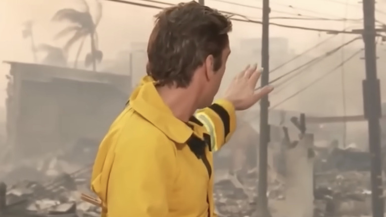 David Muir gestures while wearing jacket with clothespin on the back