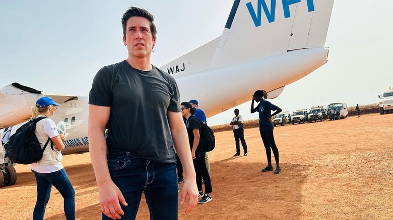 David Muir stands in front of plane in South Sudan
