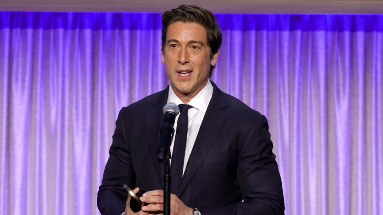 David Muir accepting a Peabody Award in front of a microphone.